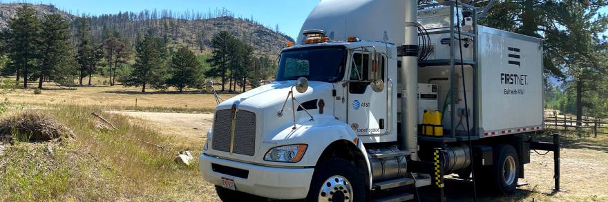 A FirstNet Satellite Cell on Light Truck parked outside and surrounded by trees
