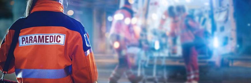 A paramedic stands near an incident scene