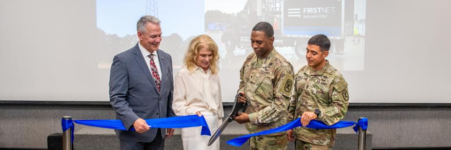 Fort Benning Garrison Commander Colonel Jerel Evans, along with representatives from the U.S. Army, FirstNet Authority, and AT&T, cuts a blue ribbon.