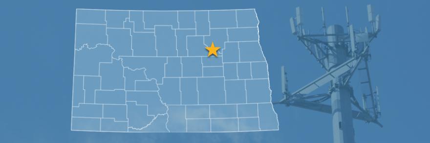 The state of North Dakota, with outlined county borders and a star locating Spirit Lake Reservation, North Dakota; a cell tower.