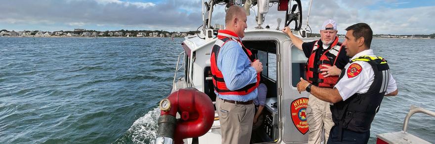 Public safety officials from Hyannis Fire speak with FirstNet Authority representatives while on an emergency response boat off the coast of Massachusetts.