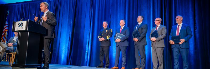 2024 Patriot Award winners stand with their certificates behind Joe Wassel