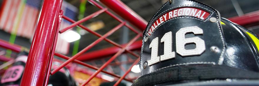 Valley Regional and Fire helmet on display in front of American flags