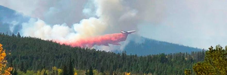 FirstNet Authority logo; “Best Practices: FirstNet use in wildland fire incidents;" plane releasing flame retardant over a forest