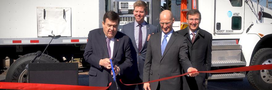 Congressman C.A. Dutch Ruppersberger cuts a red ribbon as FirstNet Authority Acting CEO Ed Parkinson looks on in front of an AT&T Satellite Cell on Light Truck