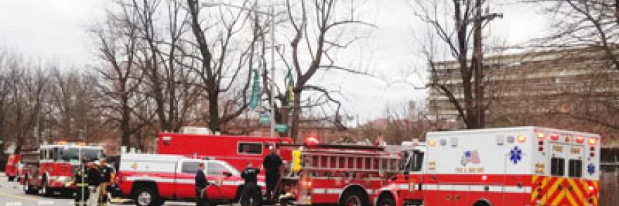 Two firetrucks, an ambulance, and other emergency vehicles gather at an incident by the side of the road