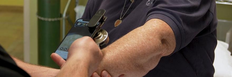 Jackman paramedic using a telemedicine application on a FirstNet-enabled smartphone while tending to a patient