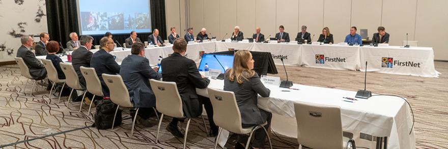 FirstNet Authority Board members sit at tables facing each other during a Board meeting 