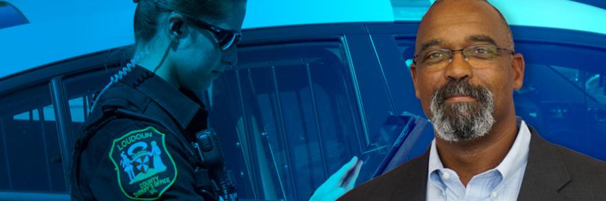 A police officer uses a tablet while standing by a police patrol car; headshot of Harry Markley