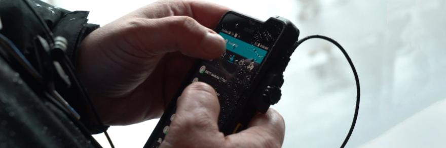 A first responder uses an application on a smartphone.