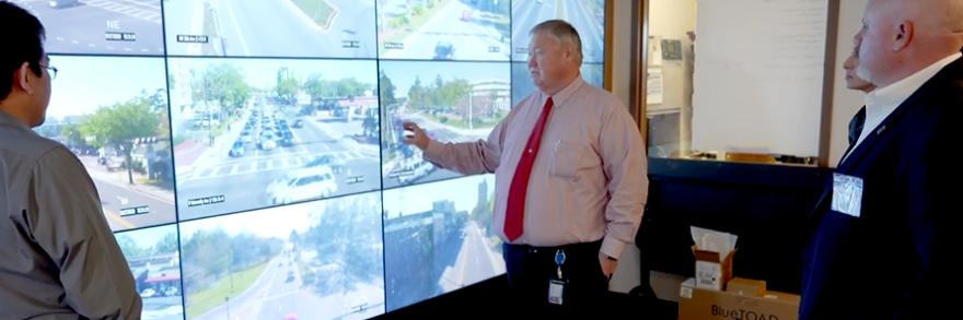 Public works staff from Gainesville, Florida consult several screens showing live stream video from around the city. 
