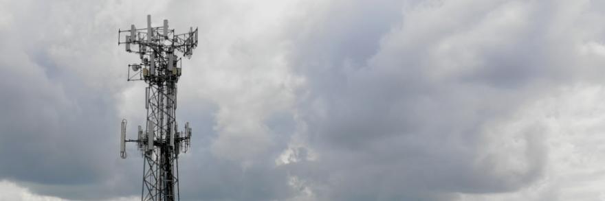 A cell tower in front of a cloudy sky