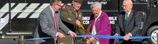 Deputy Commanding General of Army Materiel Command Lieutenant General Donnie Walker cuts a ribbon held by FirstNet Authority Board member Chief Richard Carrizzo, Alabama Governor Kay Ivey, and AT&T Alabama President Wayne Hutchens in front of a FirstNet Emergency Mobile Communications truck.