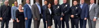 A group of FirstNet Authority, LAPD, and AT&T personnel posed in front of an LAPD office