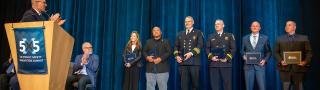 Six 2025 Patriot Award winners stand on stage after receiving their award
