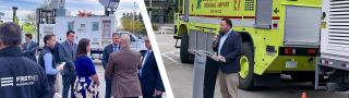 Governor Chris Sununu, public safety officials, and AT&T representatives in front of a FirstNet SatCOLT at Manchester-Boston Regional Airport; FirstNet Authority Senior Public Safety Advisor Bruce Fitzgerald speaking at a press event in front of a Manchester-Boston Regional Airport fire vehicle.