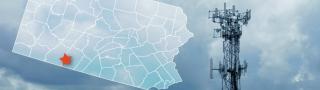 The state of Pennsylvania, with outlined county borders; star marking Hyndman in Bedford County; a FirstNet cell tower