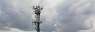 A cell tower in front of a cloudy sky