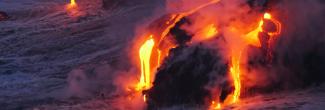 Orange lava flows down the side of a volcano