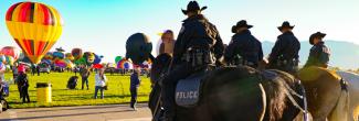 Group of New Mexico police officers riding on horseback monitoring the annual Albuquerque International Balloon Fiesta.