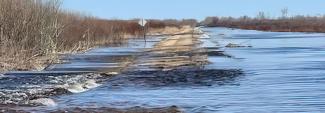 A road in Minnesota partially submerged in water from a recent flood. 