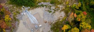 Overhead view of a Maine FirstNet cell tower in a rural area surrounded by trees.