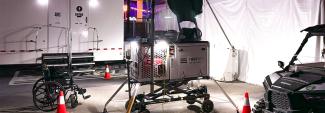 A FirstNet Compact Rapid Deployable set up near medical tents at the Electric Daisy Carnival. Trailer, wheelchair, side-by-side vehicle, and orange cones. 