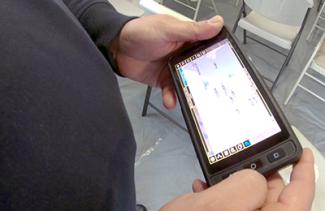 A FirstNet enabled phone held by an officer displaying an app