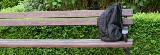 A backpack on a bench in a park