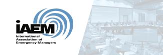 International Association of Emergency Managers (IAEM) logo and image of IAEM representatives making a presentation at a FirstNet Authority Board Meeting.